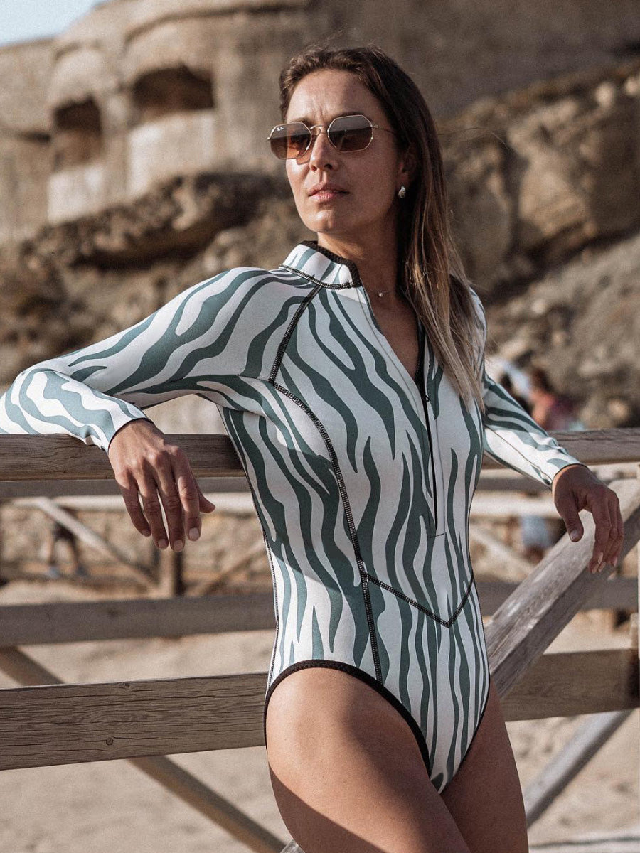 This is a one-piece swimsuit with a full-body zebra print. It has black lines on it. It is very slim-fitting. It has a zipper on the chest and long sleeves.